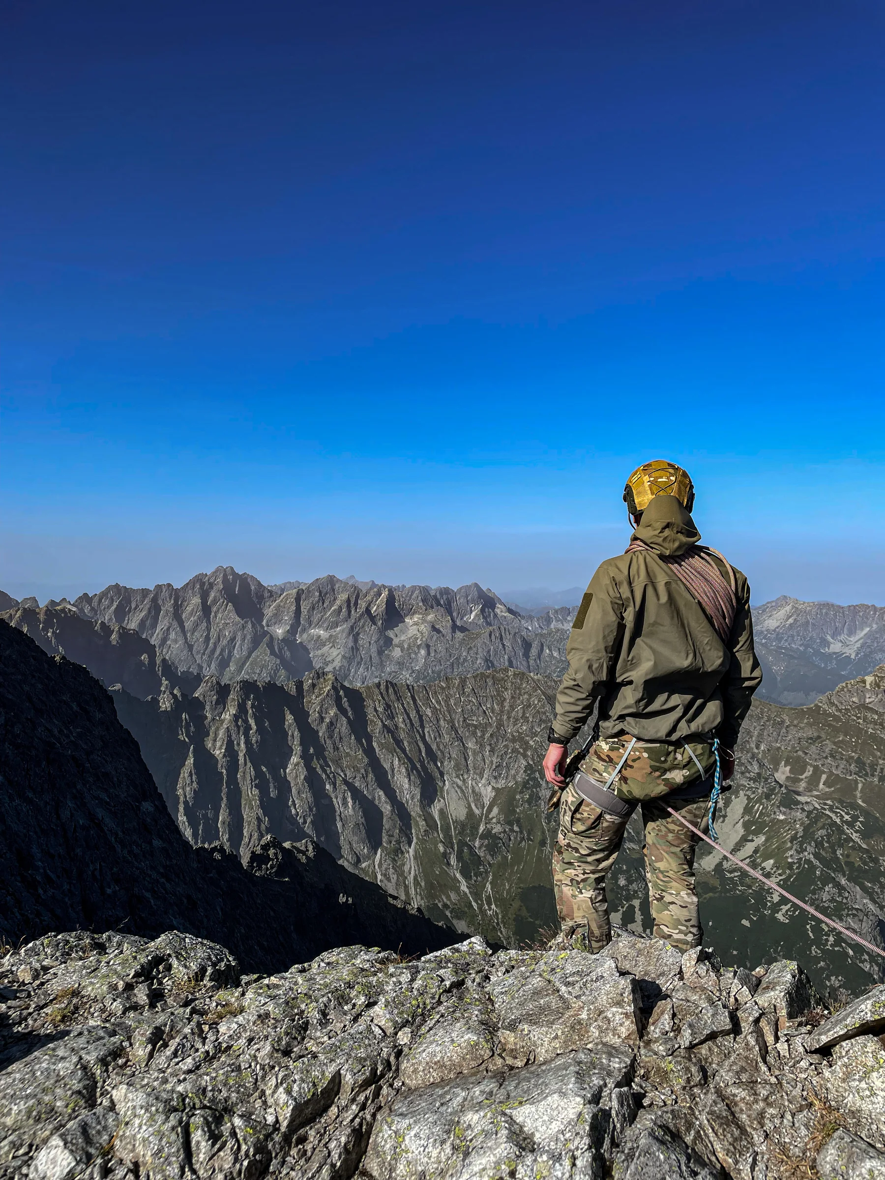 Climber on a rocky mountain ridge overlooking the surrounding peaks