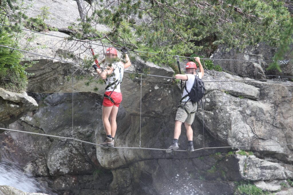 Climbers on the cable bridge above the Stuibenfall waterfall in Tyrol