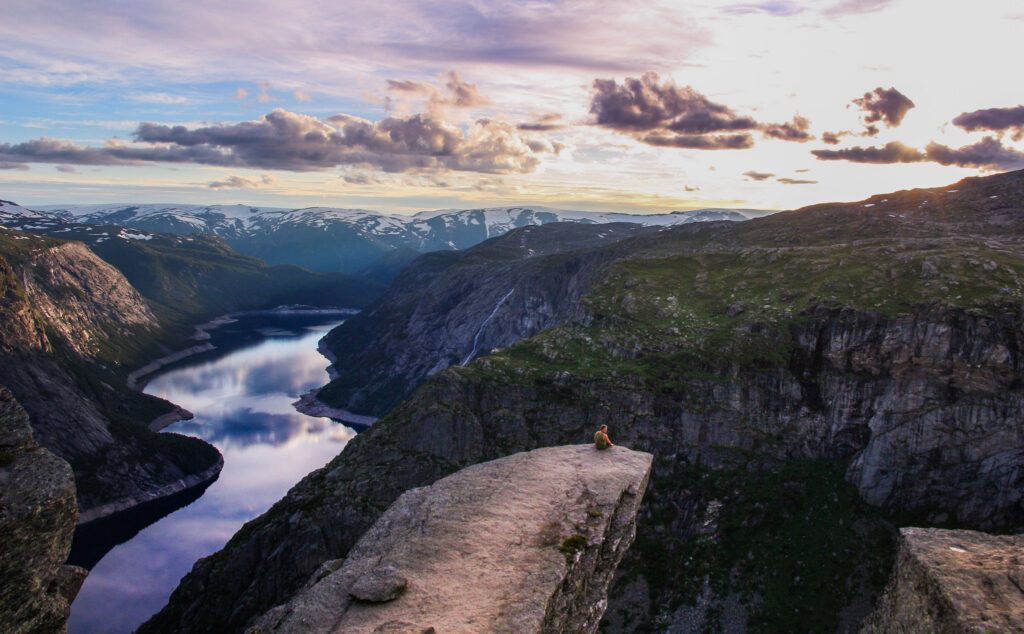 Skalní výběžek Trolltunga nad jezerem Ringedalsvatnet při západu slunce